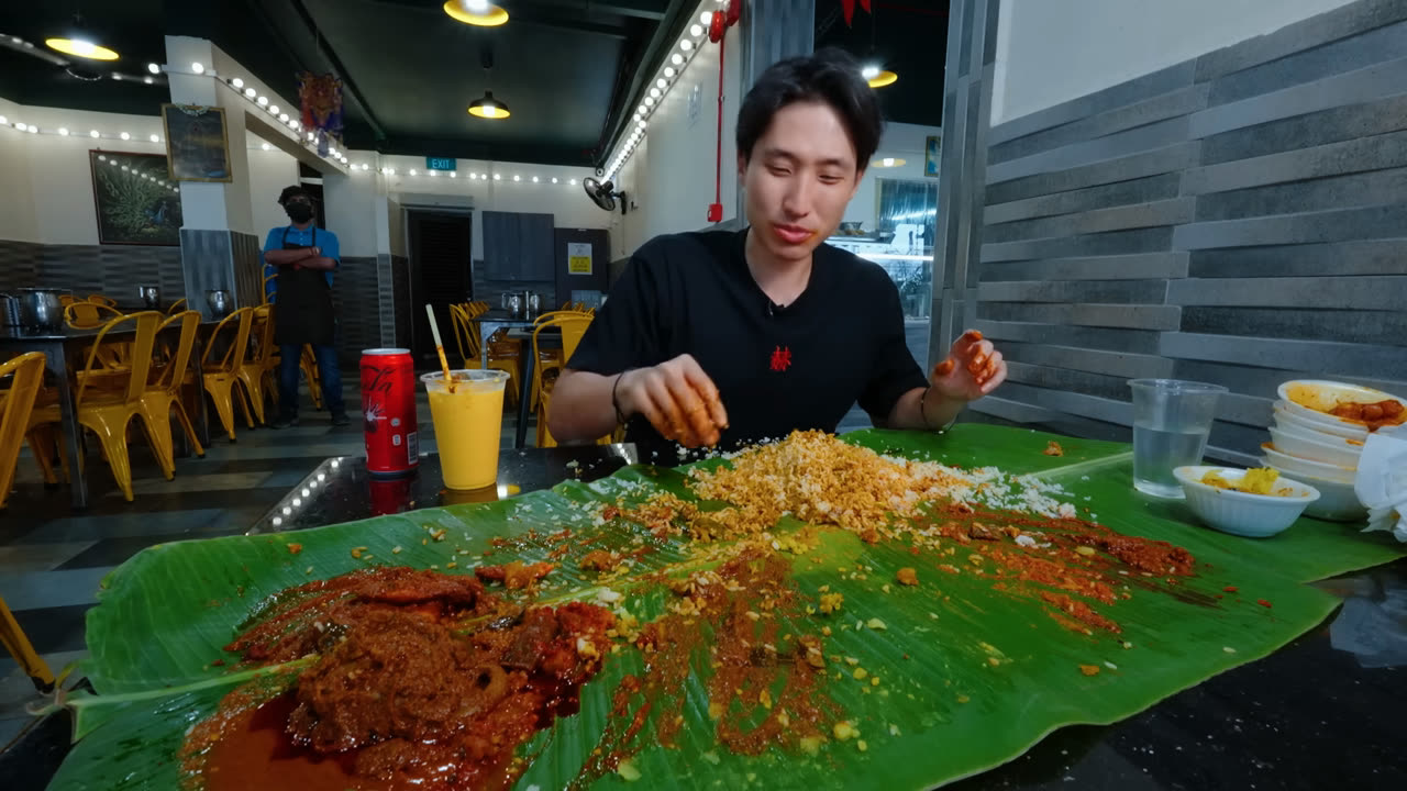 Zermatt Neo eating rice and curries from a long banana leaf at Gandhi Restaurant